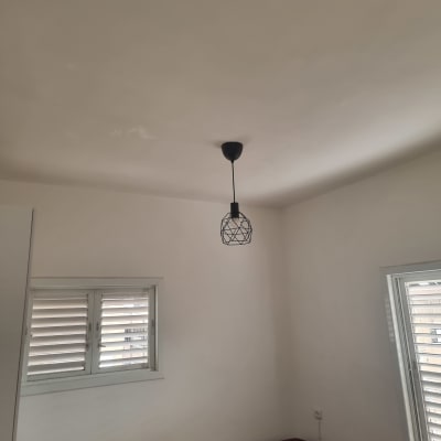 חדר צבוע עם מנורה תלויה ותקרה חלקה