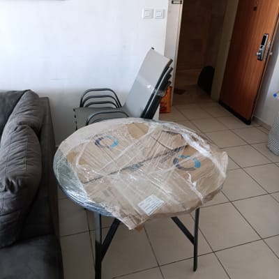 שולחן עגול עטוף בניילון עם כיסאות מוערמים