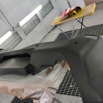 חלק רכב בתהליך צביעה בחדר צבע מקצועי