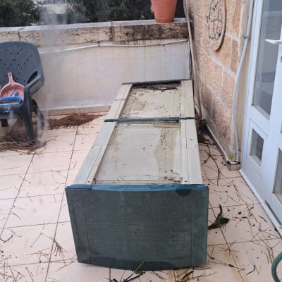 מרפסת עם רהיט הפוך, כיסא ומטאטא