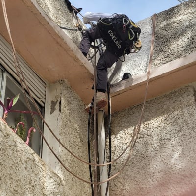 אדם מטפס על קיר עם ציוד טיפוס וחבלים
