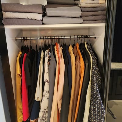 ארון בגדים מסודר עם בגדים תלויים ומקופלים