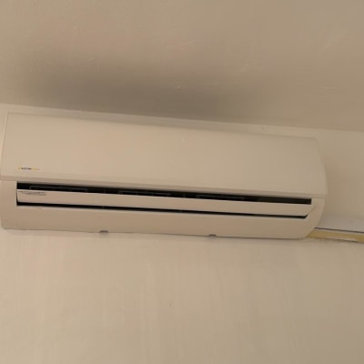 מזגן קיר לבן מותקן על קיר בהיר