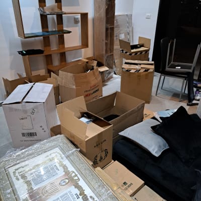 קופסאות קרטון פתוחות ליד מדף עץ להרכבה