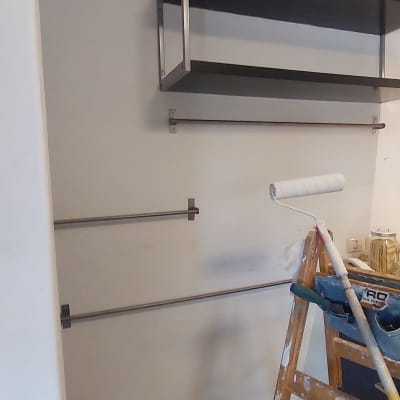 סולם עם רולר צבע ליד קיר צבוע