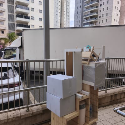 ארגזים וציוד על עגלה ליד משאית הובלה