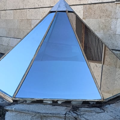 פירמידת זכוכית על גג עם צינורות וחוט חשמל