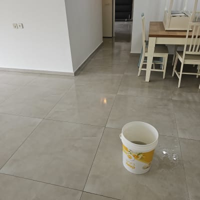 דלי צבע על רצפה חדשה בחדר ריק