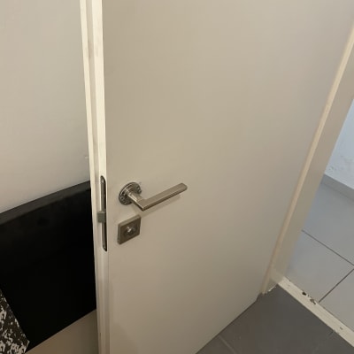 דלת לבנה עם ידית מתכת פתוחה מעט