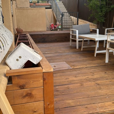 רצפת עץ עם אדניות ריקות ופרגולה מעל