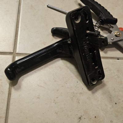 ידית תריס שחורה על רצפה עם כלי עבודה