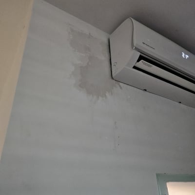קיר עם סימני רטיבות ליד מזגן