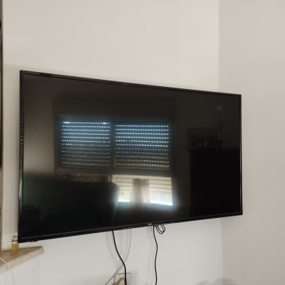 טלוויזיה תלויה על הקיר עם כבלים חשמליים