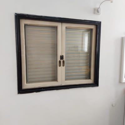 חלון זכוכית עם תריסים סגורים במסגרת שחורה