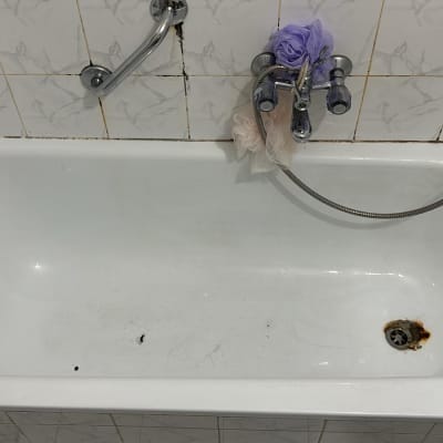 אמבטיה לבנה עם ברזים ומקלחת יד