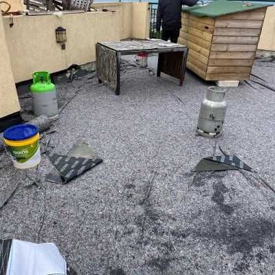 אדם עובד על איטום גג עם יריעות וחומרים