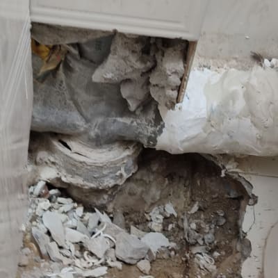 קיר שבור עם צינור חשוף ותיקוני טיח