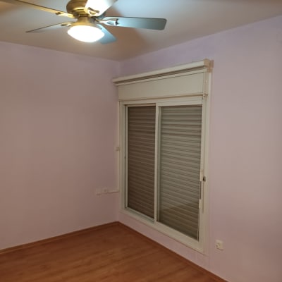 קיר צבוע בצבע סגול בהיר עם חלון ותריסים