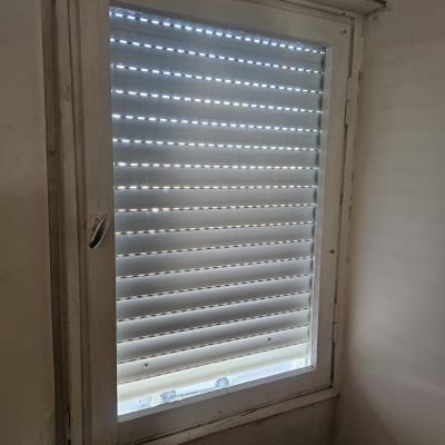 חלון עם תריסים סגורים ואור עובר דרכם