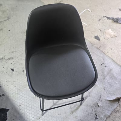 כיסא מרופד שחור על רצפה עם לכלוך