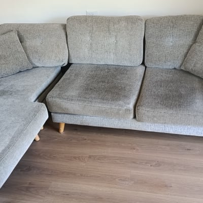 ספה אפורה עם כריות על רצפת עץ