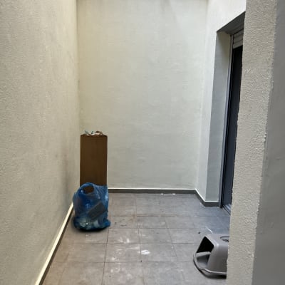 קיר צבוע בלבן עם סימני צבע על הרצפה