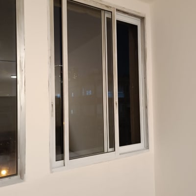 חלון אלומיניום עם מסגרת לבנה על קיר בהיר