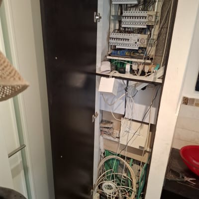 לוח חשמל פתוח עם חוטים וכלים חשמליים