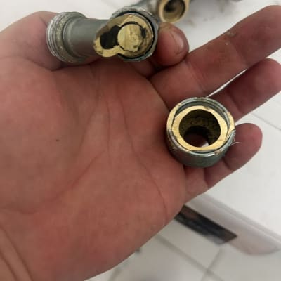 חלקי ברז ניל או מחבר צנרת פליז שבור בידו של אינסטלטור