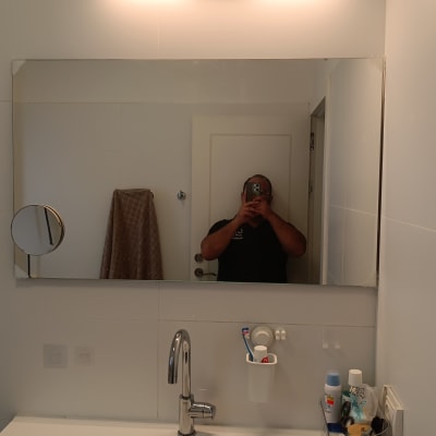 מראה עם תאורה מעל כיור בחדר אמבטיה