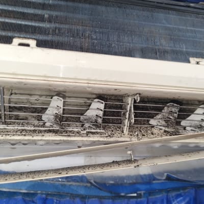 מזגן מלוכלך עם לכלוך על התריסים והפילטרים