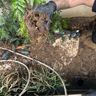 עבודת אינסטלציה עם צינורות וכלים בגינה