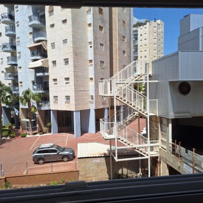 בניין מגורים עם מדרגות חיצוניות וחניה