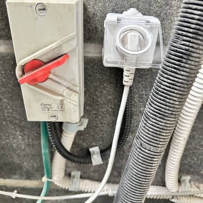 מתג חשמלי, כבלים וצינורות חשמל על קיר