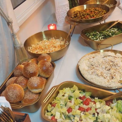 מגשי סלטים, לחמניות ואורז על שולחן קייטרינג