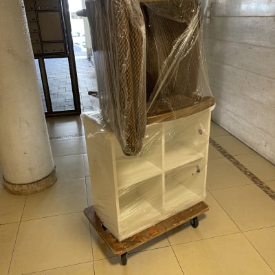 רהיטים עטופים בניילון על עגלה עם גלגלים