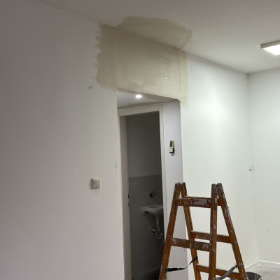 סולם ועבודת תיקון קיר עם צבע ודבק