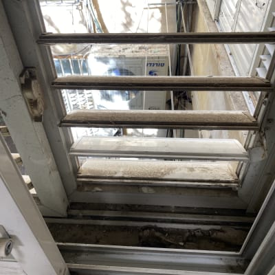 חלון מלוכלך עם אבק ולכלוך על התריסים