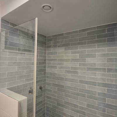 חדר מקלחת עם אריחים אפורים על הקירות