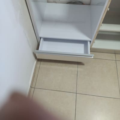 ארון מטבח עם מגירה פתוחה על רצפת קרמיקה