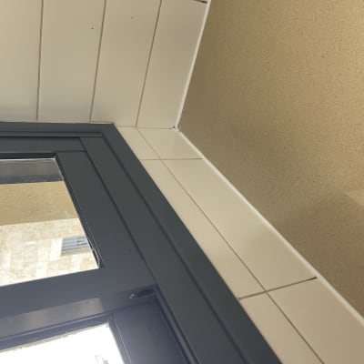 קיר צבוע בלבן עם חלון אפור