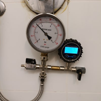 מד לחץ מים ומד דיגיטלי על קיר