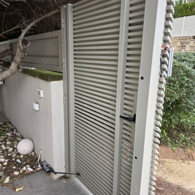 שער חשמלי אפור עם מנגנון פתיחה