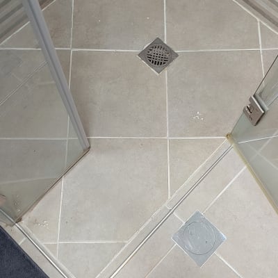 רצפת מקלחת עם ניקוז ומגף מלוכלך