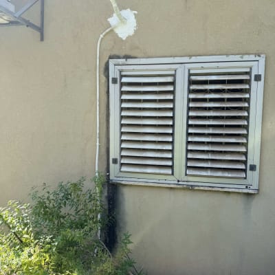 צינור מיזוג אוויר מחובר לקיר חיצוני עם תריסים