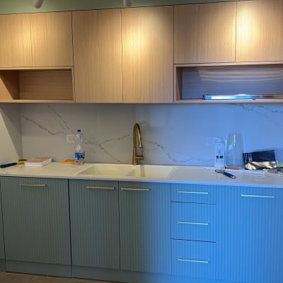 מטבח עם ארונות עץ, כיור וברז זהב