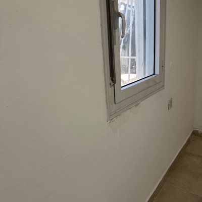 קיר צבוע בלבן עם חלון קטן