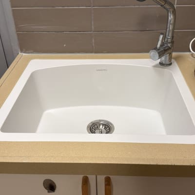 כיור עם ברז על רקע אריחים חומים