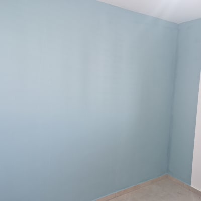 קיר צבוע בכחול עם סולם עץ בצד