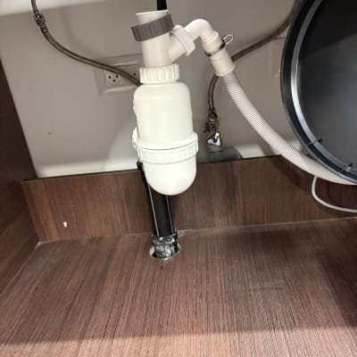 צנרת מתחת לכיור עם חיבורים וצינורות